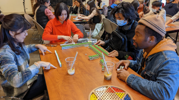 People playing Mahjong at an event and drinking boba tea