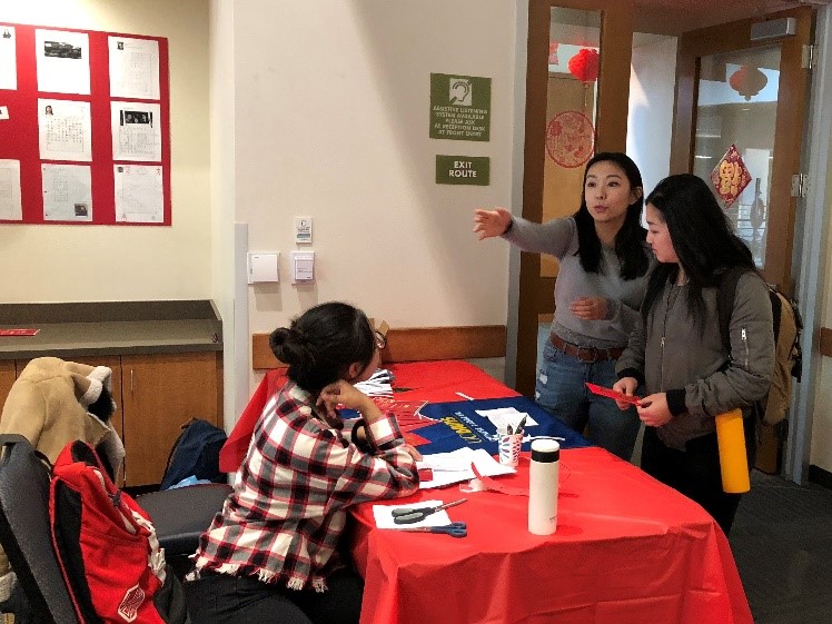 Distributing red envelops to wish attendees a lucky Year of the Dog