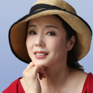 A photo of Yan Geling in a red dress and straw hat
