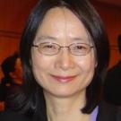 a woman with black hair and glasses