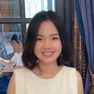Vivian Wong in a white dress standing in front of a window
